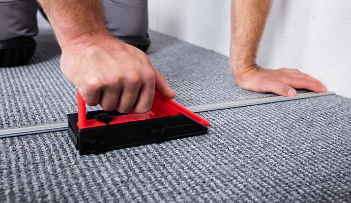 craftsman hands laying carpet stretching