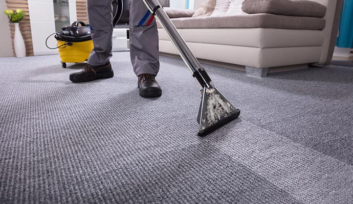 professional man carpet cleaning by vacuum cleaner