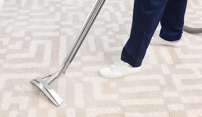 Worker removing dirt from carpet